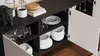 A close-up view of an open sideboard cabinet, showcasing shelves filled with dishes and glassware. Anteprima dell’immagine prodotto