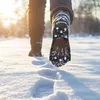 A person's legs and feet walking in the snow, leaving footprints. Podgląd zdjęcia produktu
