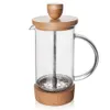 A French press coffee maker with a glass body, wooden lid and knob, and a cork base. Produktbild-Vorschau