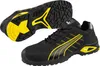 A pair of black Puma safety shoes with yellow accents, shown from a slightly elevated diagonal angle. One shoe is shown from the side, and the sole of the other shoe is visible. Voir les images du produit