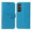 A blue flip cover phone case with a floral and butterfly embossed design is shown from the front and back. Produktbild-Vorschau