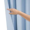 A hand is parting a light blue curtain. Produktbild-Vorschau