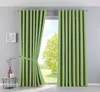 A pair of green curtains is shown hanging in front of a window with a view of trees and sky. Produktbild-Vorschau
