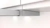A close-up view of a silver metallic flat-screen range hood installed under white kitchen cabinets. Voir les images du produit