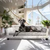 A Great Dane dog is lying on a luxurious dog sofa in a bright, modern living room with large windows and a grand staircase. Podgląd zdjęcia produktu