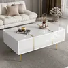A modern living room scene featuring a white high-gloss coffee table with gold accents, placed in front of a plush white sofa. Produktbild-Vorschau
