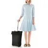 A person is standing next to a black trolley bag. Produktbild-Vorschau