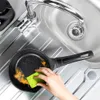 A hand is scrubbing a frying pan in a sink. Náhled obrázku produktu