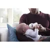 A father is feeding his baby with a bottle while sitting on a couch. Produktbild-Vorschau