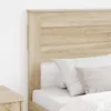 Close-up of a wooden headboard with pillows on a bed. Voir les images du produit