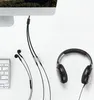 A computer monitor with cables connected to headphones and earbuds, next to a keyboard. Anteprima dell’immagine prodotto