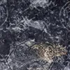 A close-up view of a dark fabric with a distressed, patterned design. Anteprima dell’immagine prodotto