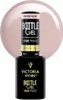 A bottle of Victoria Vynn Bottle Gel nail polish in the shade 'Naked Nude', shown against a soft pink, out-of-focus background. Náhled obrázku produktu