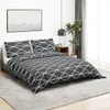 A bedroom scene with a bed made with a gray and white geometric patterned duvet cover and pillows. Náhľad obrázku produktu