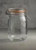 A clear glass jar with a metal clasp and an orange rubber seal sits on a textured gray surface. Anteprima dell’immagine prodotto