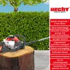 A hedge trimmer is placed on a tree stump in front of a manicured hedge and a tree. Produktbild-Vorschau