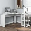 A white L-shaped desk with shelves in a room with a window and a radiator. Produktbild-Vorschau