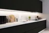 A modern black kitchen with a white countertop and backsplash. Produktbild-Vorschau