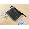 A black paper cutter with a white ruler guide sits on a wooden surface, with a few photos scattered around it. Produktbild-Vorschau