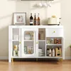 A white sideboard with glass doors and gold legs, filled with various kitchen items and decor. Produktbild-Vorschau