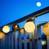 A string of LED lights with spherical shades hangs from a railing against a twilight sky. Náhled obrázku produktu