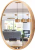 A round wooden mirror reflects a modern living and dining area with furniture and pendant lights. Anteprima dell’immagine prodotto