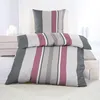 A neatly made bed with striped bedding and a pillow. Produktbild-Vorschau