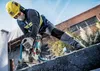 A construction worker is using a power tool to cut concrete. Voir les images du produit