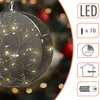 A close-up of a decorative glass sphere with LED lights inside, set against a blurred background of a Christmas tree with red and gold ornaments. Anteprima dell’immagine prodotto