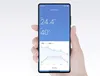 A hand holding a smartphone displaying a temperature and humidity monitoring app. Podgląd zdjęcia produktu