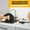 A person is cleaning a raclette grill plate in a kitchen sink, with cleaning supplies nearby. Anteprima dell’immagine prodotto