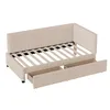 A beige upholstered daybed with two drawers underneath, shown from a diagonal angle against a white background. Anteprima dell’immagine prodotto