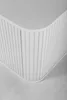 A close-up view of the corner of a white cabinet with vertical ribbed detailing. Produktbild-Vorschau