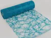 A roll of turquoise decorative fabric with a swirling pattern. Produktbild-Vorschau