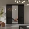 A modern bedroom or living room setting with a large black wardrobe with mirrored doors. Náhled obrázku produktu