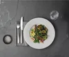 A table setting with a salad, cutlery, salt, and a glass of water. Produktbild-Vorschau