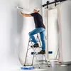 A man is painting a wall while standing on a stepladder. A large sliding mirror door is visible in the background. Náhľad obrázku produktu