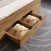 Close-up view of the drawers of a wooden bed frame, showing two beige pillows with satin ribbons tied around them. Náhled obrázku produktu