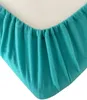 A close-up view of the corner of a turquoise fitted sheet, showing the elasticized edge. Produktbild-Vorschau