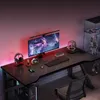 A gaming desk setup with a monitor, keyboard, headphones, and decorative lighting. Podgląd zdjęcia produktu