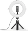 A white LED ring light with a black smartphone holder is mounted on a black tripod. A black cable extends from the base of the ring light. Produktbild-Vorschau
