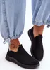 Close-up of a person's feet wearing black slip-on sneakers and light blue jeans. Náhľad obrázku produktu