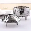 Two stainless steel steamer baskets are displayed on a white surface, with a blurred background suggesting a kitchen setting. Produktbild-Vorschau