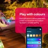 An outdoor patio scene at night, with colorful lights illuminating a hanging chair and surrounding plants. A smartphone screen displaying a lighting control app is shown in the foreground. Produktbild-Vorschau