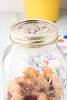 A close-up shot of a Kilner jar filled with cookies, with a yellow object in the background. Podgląd zdjęcia produktu