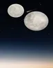 Two moons and a comet in a starry night sky, with a gradient of dark blue to light orange at the bottom. Náhled obrázku produktu