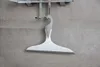 A squeegee hangs from a hook on a tiled wall. Produktbild-Vorschau