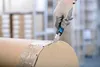 A gloved hand is using a utility knife to cut through the tape on a large cardboard roll. Voir les images du produit