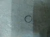 A metal ring is placed on a wooden surface. Produktbild-Vorschau