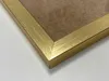 A close-up view of the corner of a gold picture frame. Voir les images du produit